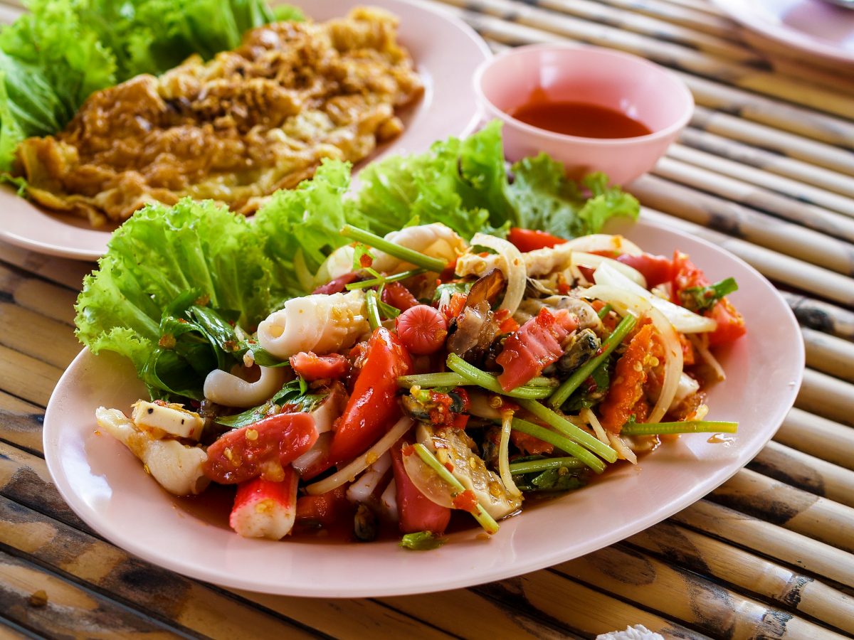 A spread of low-carb ingredients and prepared dishes on a kitchen table.